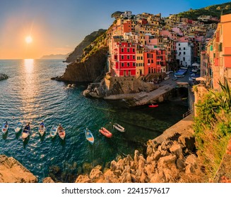 Sunset view onto the Mediterranean Sea with traditional boats and colorful houses in old town of Riomaggiore in Cinque Terre, Italy - Shutterstock ID 2241579617