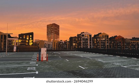 Sunset view over an empty parking lot with silhouetted buildings