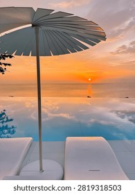 Sunset view over infinity pool and ocean with beach umbrella infinity umbrella vacation tranquil