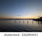 Sunset view over a large river with a cityscape in the distance.