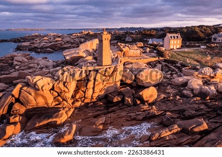 Sunset view of the Ploumanac'h Lighthouse (the Mean Ruz Lighthouse) in Perros-Guirec on the Pink Granite Coast or Côte de Granit Rose. Brittany, France.
