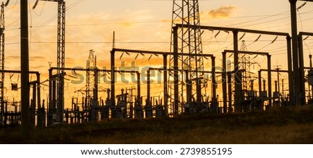 Sunset view of power lines and electrical towers in a field during late afternoon in a rural area