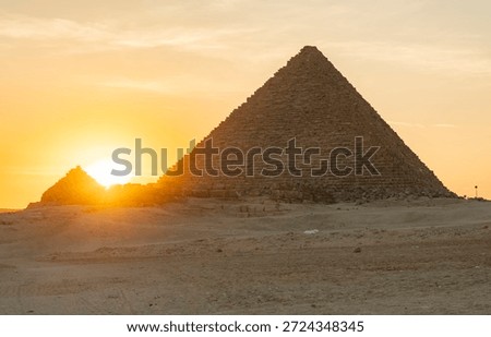 Sunset view of pyramid in desert with setting sun in background near Giza, Egypt