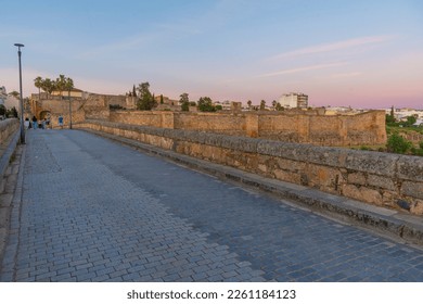 Sunset view of roman bridge over river Guadiana leading to Alcazaba fortress in Merida, Spain