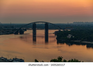 Sunset, View Of The Rusty Unfinished Bridge In Kiev, Ukraine. Known For Its Unusual Design And Very Beautiful And Unusual Bridge Is Popular Among Tourists. Concept, Tourism, Travel.