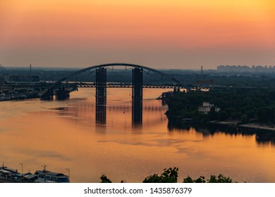 Sunset, View Of The Rusty Unfinished Bridge In Kiev, Ukraine. Known For Its Unusual Design And Very Beautiful And Unusual Bridge Is Popular Among Tourists. Concept, Tourism, Travel.