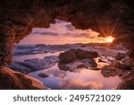 Sunset view from the sea cave. Sunset Framed by Coastal Rocks. Cyprus.