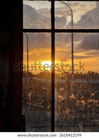 Sunset view through a dirty window pane.