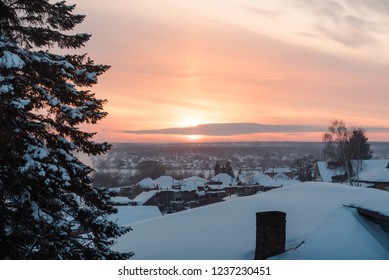 Sunset view from the window. The sun sets over the horizon. Sunset in winter among the trees and houses. Magical and wonderful winter landscape. The beauty of Russian nature - Powered by Shutterstock