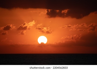 Sunset View, Yellow Bright Sun Disc On Natural Orange Sky Background. Sunset Idea Concept. Summer Cloudy Sky Landscape. Horizontal Photo. No People, Nobody.