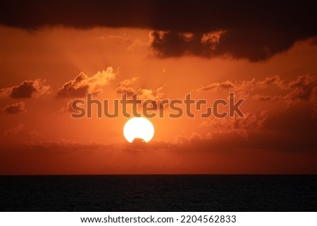 Sunset view, yellow bright sun disc on natural orange sky background. Sunset idea concept. Summer cloudy sky landscape. Horizontal photo. No people, nobody.