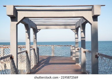 Sunset Viewpoint In Kartini Beach, Indonesia. Beach Bridge In The Port.