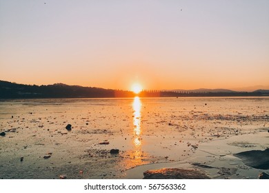 Sunset while the sun goes down on a frozen lake in northern Italy