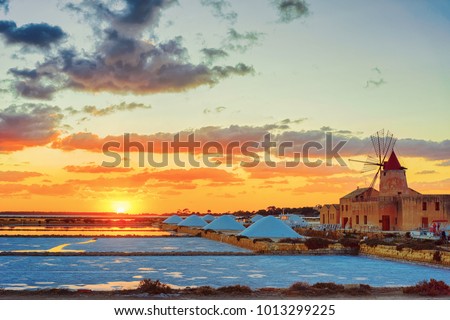 Sunset at Windmill in the salt evoporation pond in Marsala, Sicily island, Italy