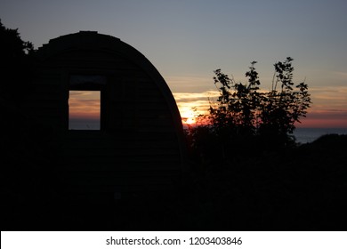 Sunset With Wooden Camping Pod In Foreground. 