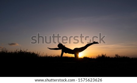 Two sisters doing gymnastics at sunset