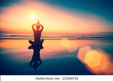 Sunset yoga on the beach, abstract photo about healthy lifestyle. - Shutterstock ID 213366718