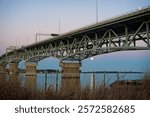 Sunsets falls as a full moon rises behind the Coleman Bridge in Yorktown, VA