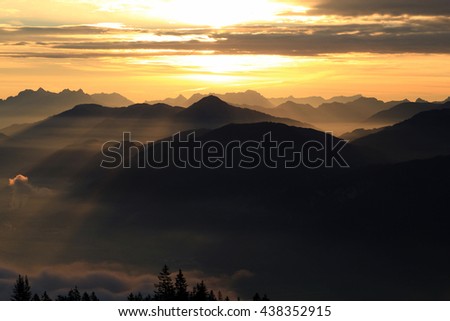 sunset/sunrise in mountains of the alps. Mountains appear as silhuettes because of the light setting.