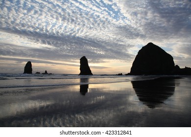 Sunsetting on the sandy beach with large boulders on beach