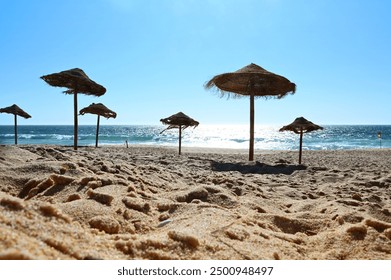 Sunshades on the vacation beach with glittering sunset sea. Tropical sunbathing and relaxation. Holiday feeling and relaxation in the resort. - Powered by Shutterstock