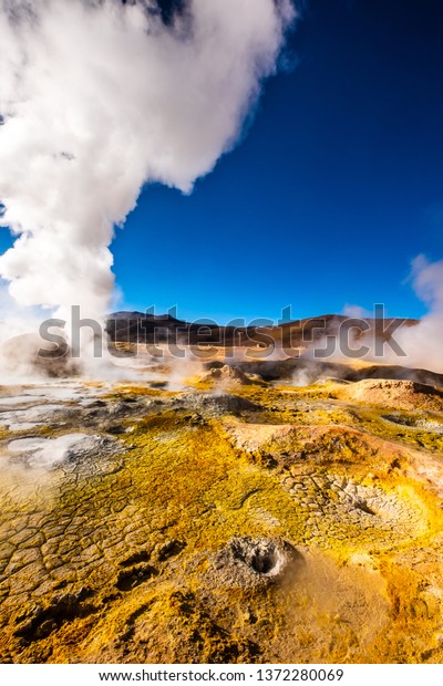 Sunshine Boivian desert landscape with huge\
steaming geysers