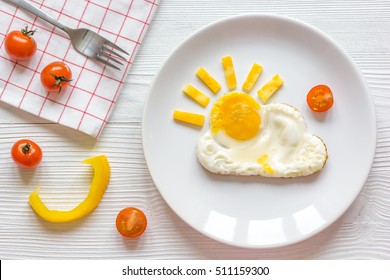 sunshine fried eggs breakfast for kid on wooden background
