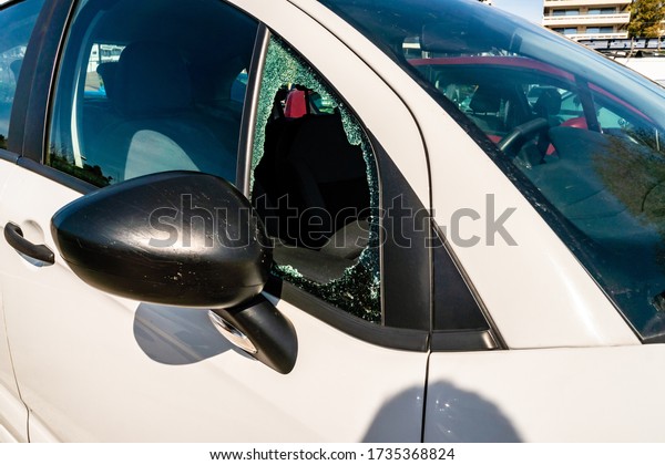 sunshine on modern\
white car with broken\
window