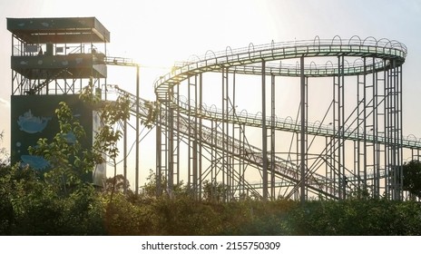 Sunshine over fun-looking empty rollercoaster ride at a fairground