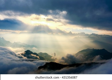 sunshine through clouds on mountain peak