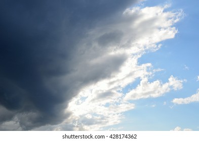 sunshine through dark thunder clouds in summer