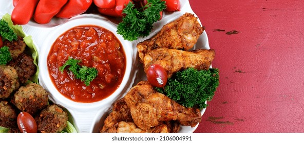 Super Bowl Sunday Football Party Celebration Food Platter With Chicken Buffalo Wings, Meat Balls, Hot Dogs On Red Wood Table, With Copy Space. Sized To Fit Popular Social Media And Web Banner.