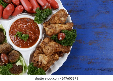 Super Bowl Sunday Football Party Celebration Food Platter With Chicken Buffalo Wings, Meat Balls, Hot Dogs And Salsa Dip On Blue Wood Table.