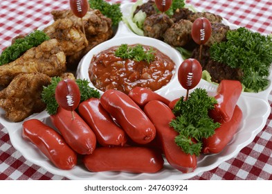 Super Bowl Sunday Football Party Celebration Food Platter With Chicken Buffalo Wings, Meat Balls, Hot Dogs And Salsa Dip On Red Check Table Cloth.