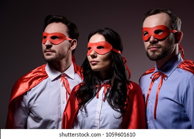 super businesspeople in masks and capes looking away isolated on grey - Powered by Shutterstock