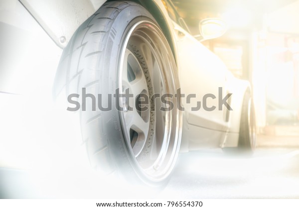 Super car back\
wheel and smoke on road with copy space using as background sport,\
transportation concept.