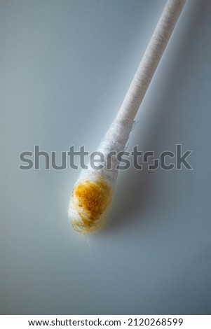 Super close up macro shot from a used and therefor dirty cotton swab showing earwax.