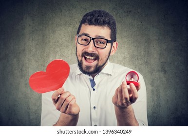 Super Excited Man With Red Heart Shape Wedding Ring Box. Romantic Proposal Concept