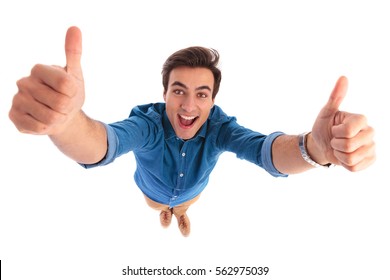 Super Excited Young Casual Man Screaming While Making The Ok Thumbs Up Hand Sign On White Background, Wide Angle Picture