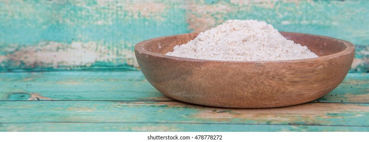 Super food maca powder in wooden bowl over wooden background