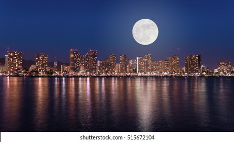 Super full moon over Honolulu downtown at night