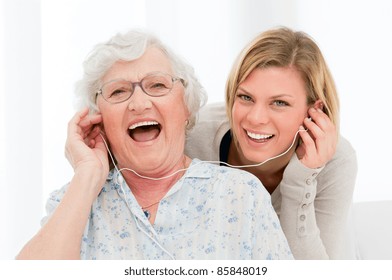 Super happy and excited grandmother listening music with her granddaughter at home