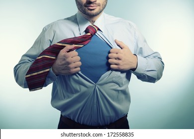 Super Hero. Business Man Opening His Shirt Like A Superhero, Over Blue Background