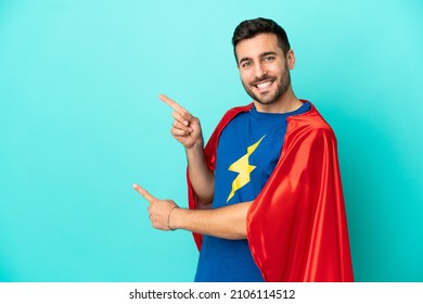 Super Hero Caucasian Man Isolated On Blue Background Pointing Finger To The Side And Presenting A Product