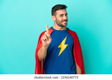 Super Hero Caucasian Man Isolated On Blue Background Showing And Lifting A Finger