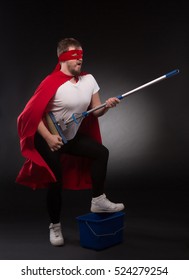 Super Hero Rock Star Playing Guitar While Posing For Photographer. Super Hero Man Ready For Cleaning Your Office Or House In Studio.