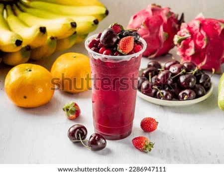 Super Mixed Berry Juice with strawberry, blueberry, blackberry, raspberry, cherry and cranberry raw fruits served in disposable glass isolated on background top view taiwan food
