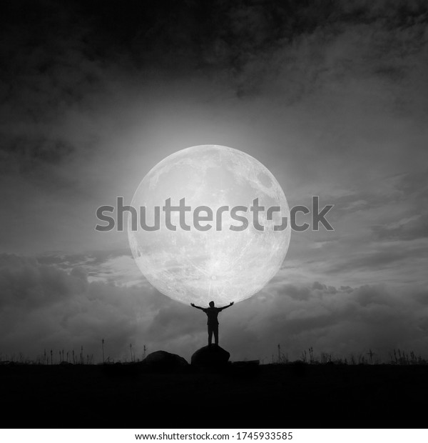 Super Moon and the lonely man in black\
and white photography. Combine and multiply\
photos