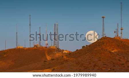 Super Moon Rising over Red Mountain in Reno Nevada with Radio Towers