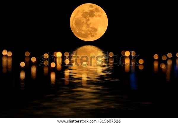 Super\
moon yellow and shadows in the water and\
bokeh.